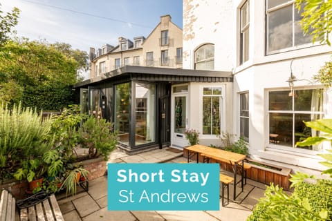 Sunny garden patio and glass-front entrance at self-catering apartment in St Andrews.