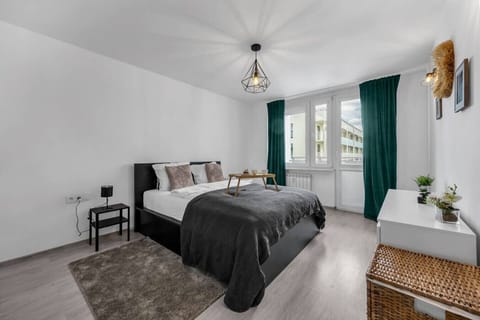 Bedroom – Spacious and bright room with a double bed, mirrored wardrobe, dresser, and elegant decor with green curtains | Book Now with RENTUJEMY.COM