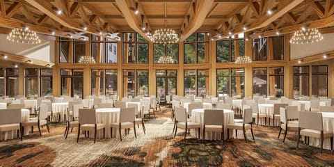 Event space filled with round tables and large windows.