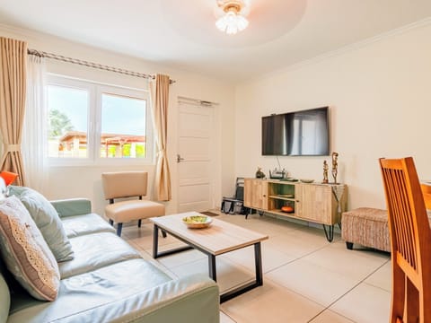 Relax in a spacious living area with cozy sofas, a large flat-screen Smart TV, and natural lighting—ideal for streaming or socializing