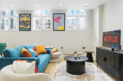 Spacious living room with bold decor, art windows, and a smart TV