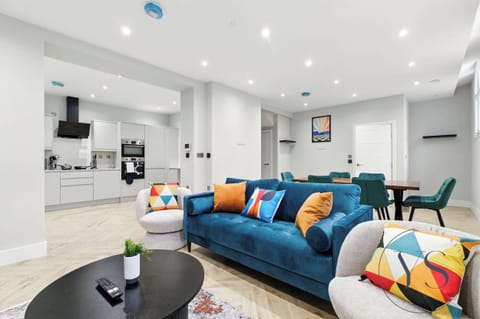 Living space with a velvet sofa, full kitchen, and dining area