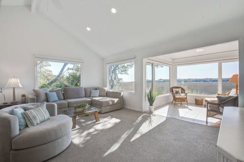 Unwind in your sun-drenched living room with panoramic water views. Natural light floods through expansive windows as you relax on plush seating.