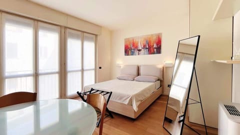 Bright double bedroom with modern furnishings and a large wardrobe.