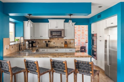 Forget bland. Our kitchen is as vibrant as your vacation should be! The pop of blue and stylish design will have you feeling energized and ready to take on the day.