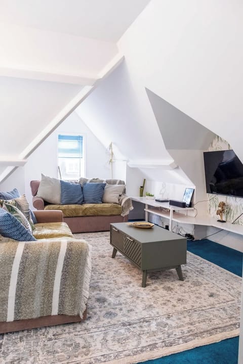 Bright, stylish loft living area with comfortable sofas, Smart TV, and coffee table — perfect for relaxing. Converts into 2 sofa beds, ideal for extra guests.