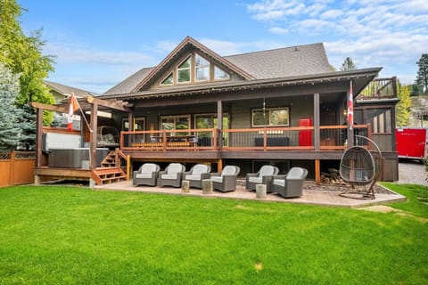 Fenced backyard of the Reef with plenty of outdoor seating, a private hot tub, a fire pit, children`s playground and lots of green space for kids & pets to safely roam.