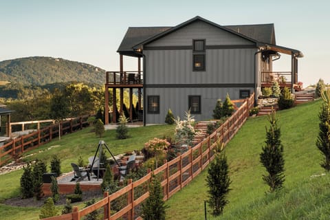 View of the backyard firepit area with the home as a backdrop. A private and inviting space to gather, relax, and enjoy the mountain setting.