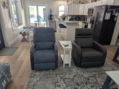 LIVING AREA LOOKING INTO FULLY EQUIPED KITCHEN