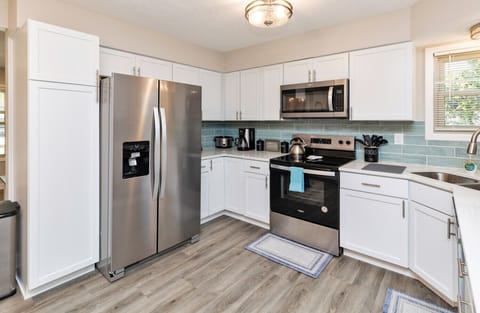 Kitchen w/ island, fridge, stove/oven, microwave, dishwasher and all kitchenware