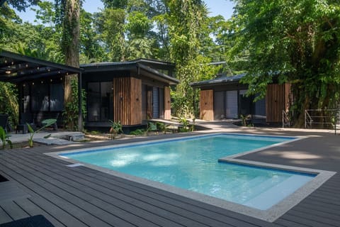 Share pool surrounded by tropical forest and modern villas at Somnara Bosque Tropical, Playa Chiquita, Costa Rica.