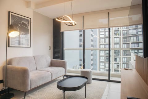 Bright living room with modern furniture and large windows.