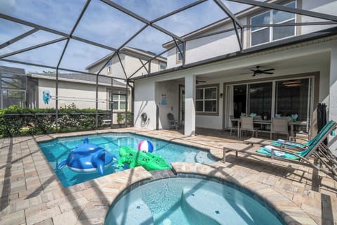 Make a splash in your private screened pool and spa! Enjoy sunny days with pool floats, lounge seating, and comfy outdoor dining-ideal for family fun and relaxation.