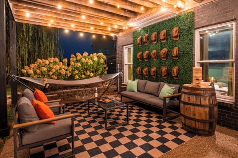 Gather outside in a charming outdoor space featuring cozy seating, authentic bourbon barrels, and a hammock made for lazy afternoons