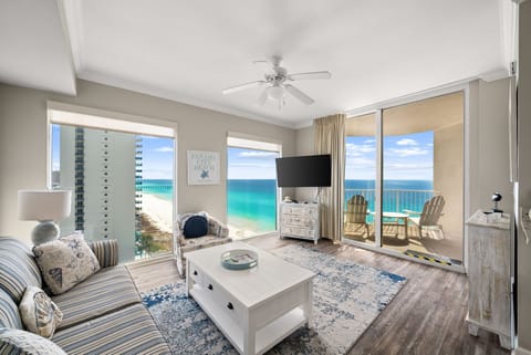Bright living room with floor‑to‑ceiling Gulf views and a breezy coastal vibe.
