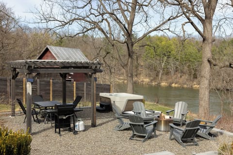 Hot tub, fire pit with Adirondack chairs, grill, dining table and seating.