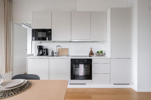 Fully equipped, minimalist kitchen with high-end appliances and a clean, modern aesthetic.