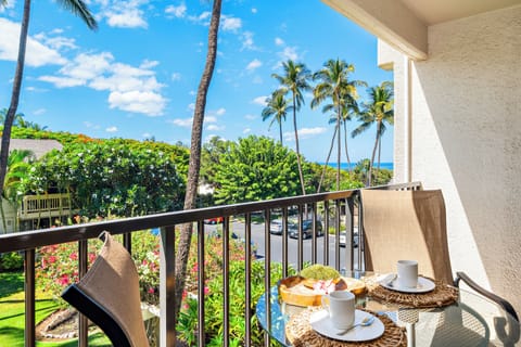Furnished lanai with tropical foliage and partial ocean view