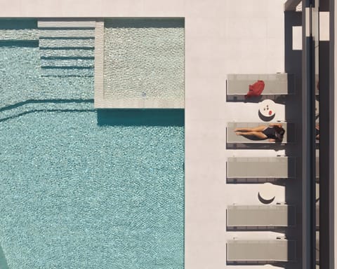 A shimmering 100m² infinity pool stretches elegantly towards the horizon.