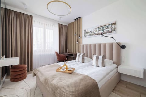 A cozy bedroom with elegant bedding and large windows ensures a restful sleep filled with natural light.