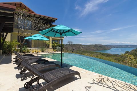 Pool area - Relax by the infinity pool under shaded umbrellas while taking in incredible ocean views