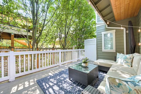 Unwind on the shaded private patio with lush greenery and cushioned seating—a peaceful downtown retreat.