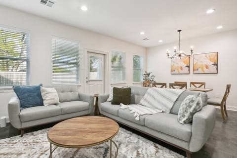 Inviting living room filled with natural light and cozy furnishings. With an open layout connecting seamlessly to the dining area, it’s the perfect space to relax or gather with loved ones.
