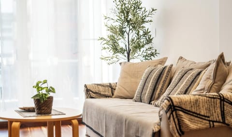 A cozy living room area featuring a neutral-toned sofa, wooden side table,