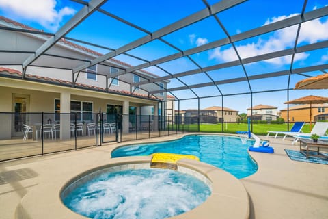 Unwind in the screened pool area featuring a bubbling spa & sunny lounge space