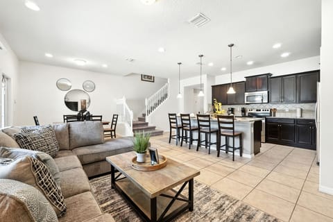 Bright, open, and inviting, this stylish living area flows seamlessly into a modern kitchen with a breakfast bar, perfect for gathering and making memories.