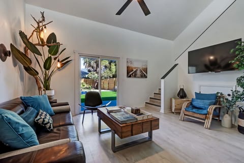 Bright boho living room with vaulted ceilings and backyard access.