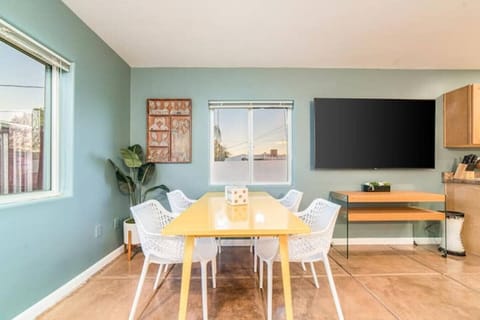 Open-concept living and dining area with 75` smart TV — perfect for meals and movie nights