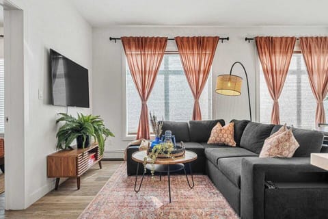 Cozy up in our bright and stylish living room featuring a plush sectional, warm natural light, and thoughtful decor perfect for relaxing after a day of exploring!