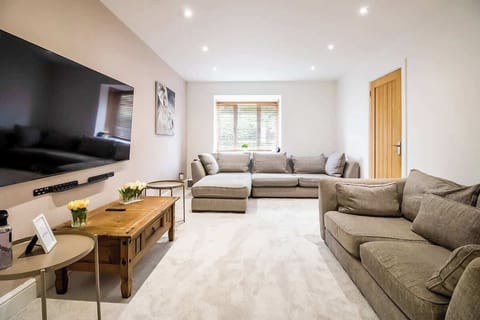 “Spacious living room with comfy sofas and a TV — perfect for family time, movie nights, or bonding with friends.”