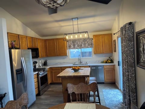 Chef Kitchen, 5 burner gas range/oven and butcher block island with stools.