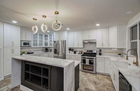 This fully equipped kitchen is decked out with luxury appliances, elegant cabinetry, and sleek countertops with a functional center island.
