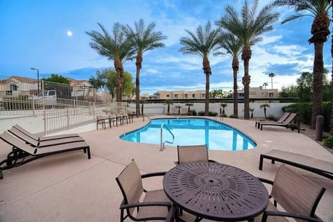 Lounge poolside under palm trees, just steps from home