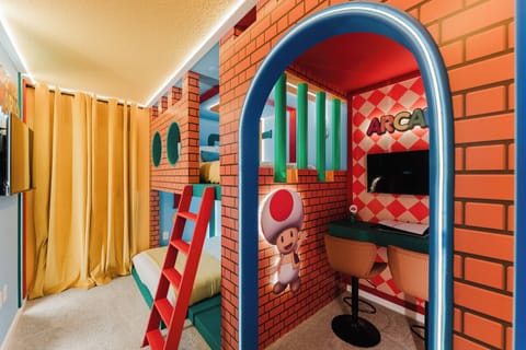 Step into a vibrant playroom adorned with playful brick-patterned walls and colorful accents. The cozy bunk beds and charming desk area invite fun and creativity, making it a perfect spot for both relaxation and adventure.