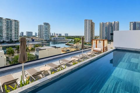 Shared rooftop infinity pool with marina and city views