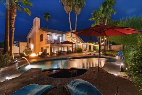The private backyard is an entertainer’s dream with a pool, spa, fire pit, outdoor dining for six, built-in BBQ grill, hammock, pool loungers, cornhole, a large grassy area, and plenty of seating for everyone to enjoy.