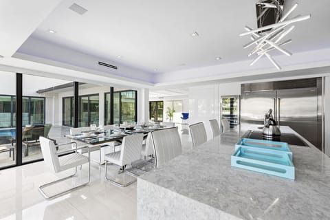 Open concept kitchen and dining with sleek appliances lots of sunlight and access to outdoors