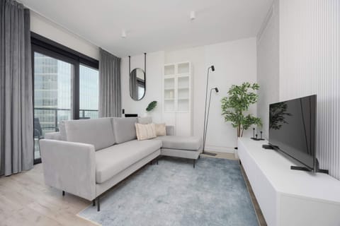 A bright living room with large windows and a comfortable sofa invites you to unwind after a long day.