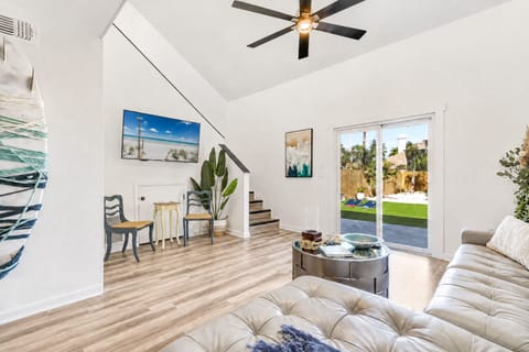Bright vaulted living room with backyard access and modern coastal style