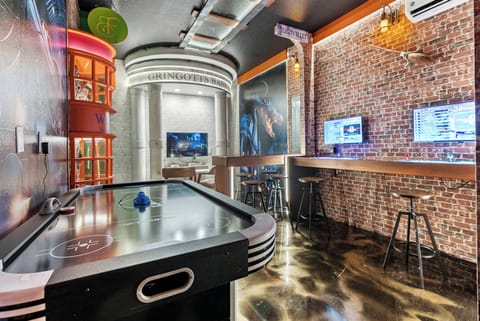 Enjoy our vibrant entertainment room featuring an air hockey table and stylish decor. The beautiful exposed brick wall and polished floors, complemented by ambient lighting, create an unforgettable atmosphere for your evenings.