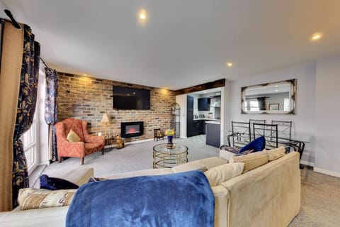 Spacious living area with exposed brick and TV