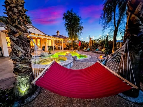 Relax in the colorful hammock overlooking the pool and lush backyard—perfect for a quiet afternoon or evening under the palms.