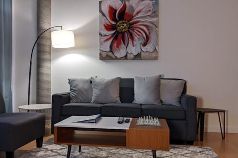 Welcome to Inner Harbour Retreat! Relax in the inviting living room lounge, featuring a plush sofa, arc floor lamp, and a coffee table equipped with a chess set for cozy evenings during your stay.
