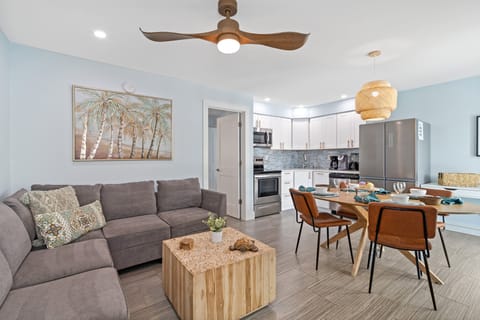 Sea Breeze's Living Area, Featuring a Pull-Out Sleeper Couch, A Dining Table, A Fully Stocked Kitchen, and a Desk.