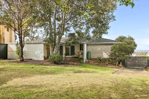 A spacious backyard shaded with trees. Lay on a picnic rug or let the kids play
