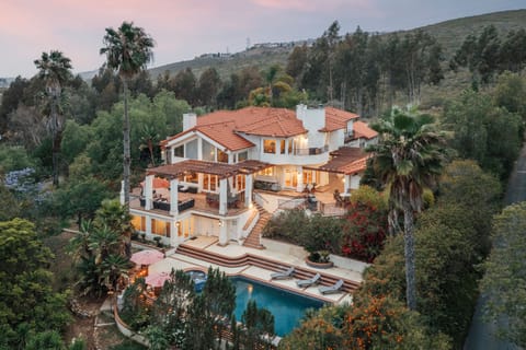 Welcome to The Ranch! A breathtaking multi-story Mediterranean estate nestled in a lush hillside enclave with a private resort-style pool.